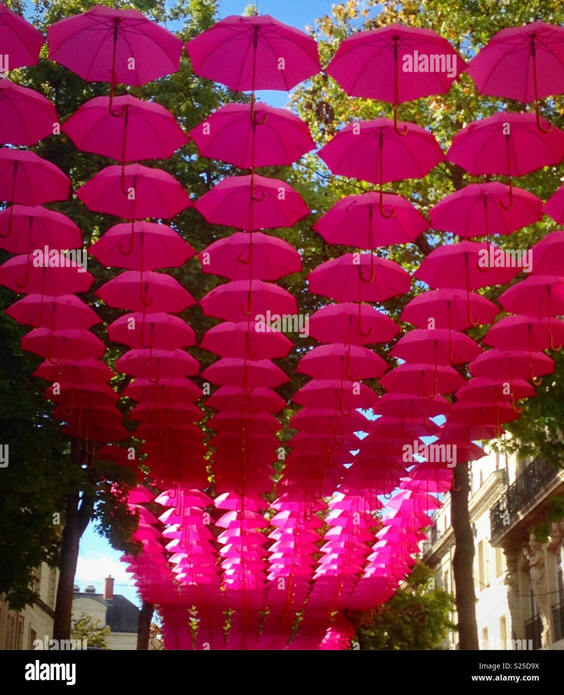 Saumur, Frankreich - 6. Oktober 2017: Street Art Installation mit rosa Regenschirmen, Saumur, Frankreich - Smartphone-aufgenommenes Stockfoto