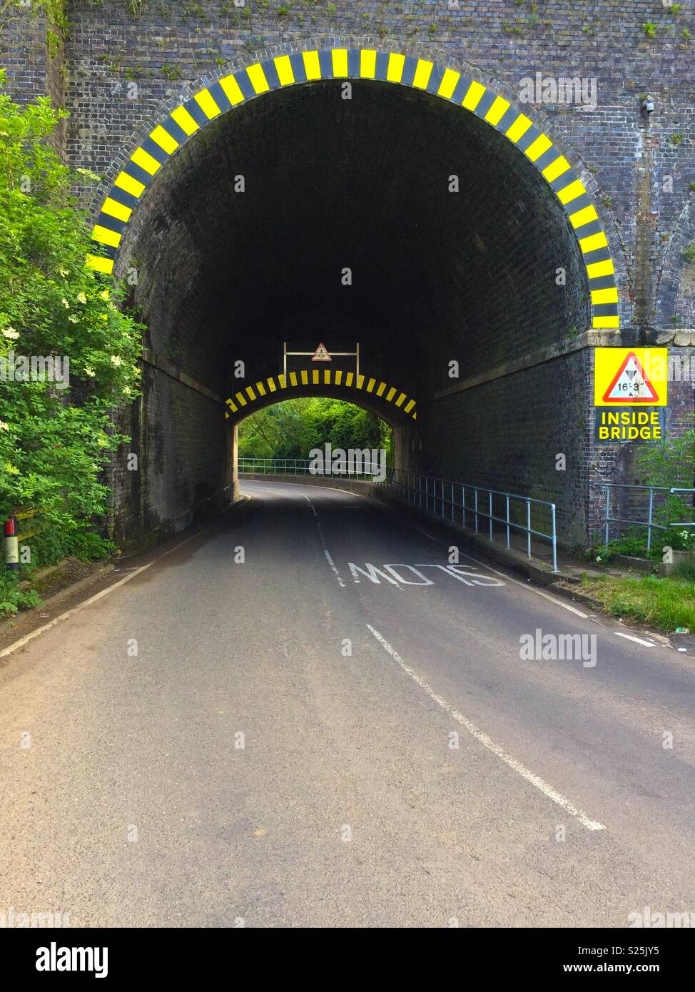 Low Road Bridge unter Bahn mit Warnung Chevrons Stockfoto