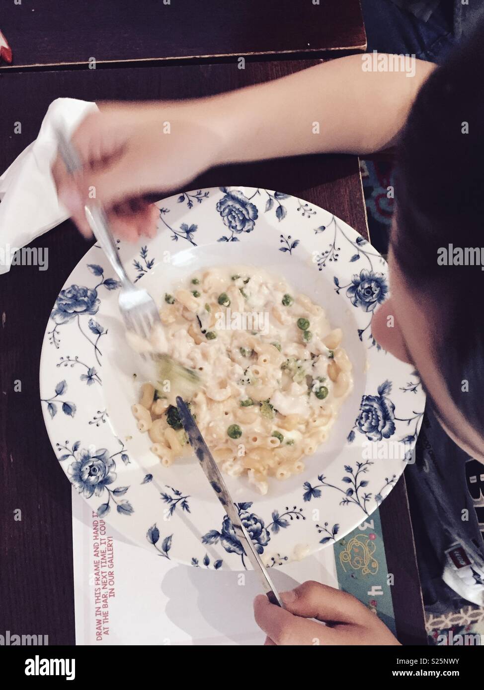 Ein Junge essen eine Schüssel mit cheesy Pasta. Stockfoto