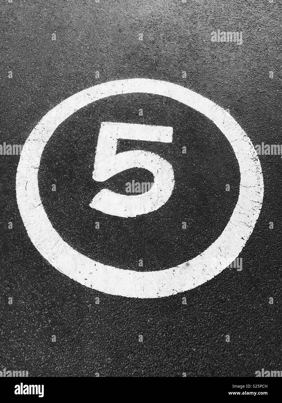 Eine Nummer 5 auf einer Straße bemalt 5 mph Höchstgeschwindigkeit zu bezeichnen. Stockfoto