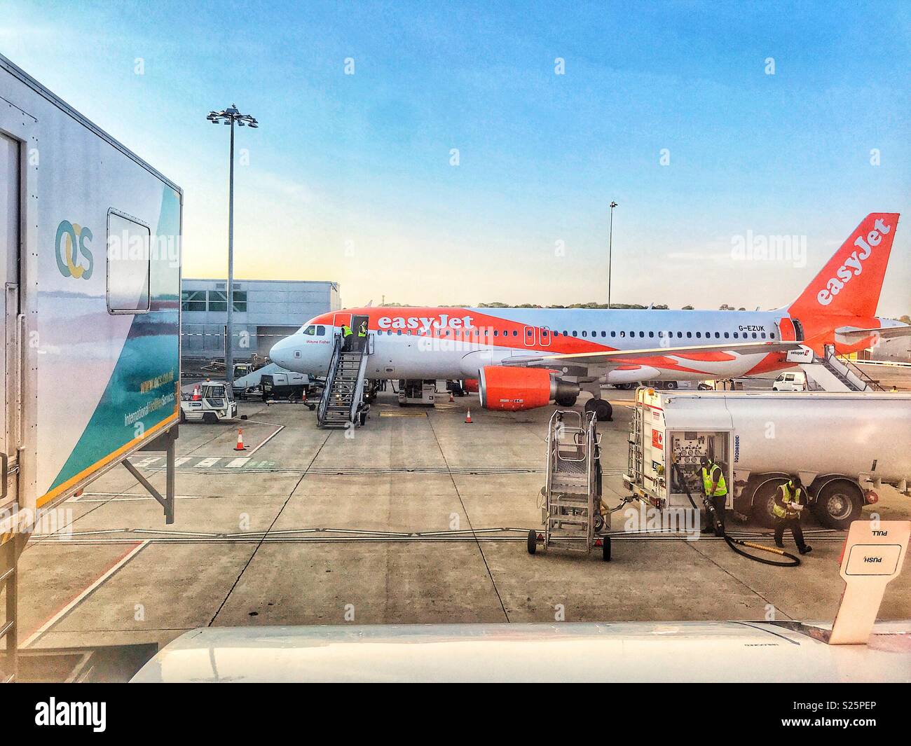 Blick aus dem Fenster von einem EasyJet Flugzeug mit einer Ambi heben Sie betankt werden, auf einen anderen EasyJet Flugzeug warten auf den Asphalt, der Flughafen Bristol, England Stockfoto