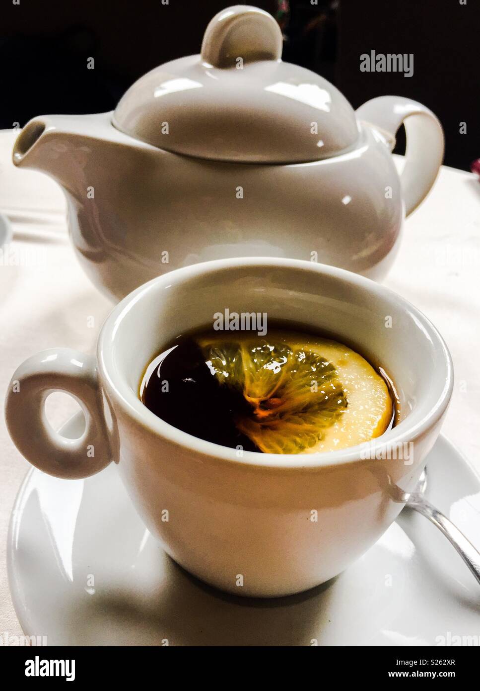 Weisse Teekanne, Tasse und Untertasse mit schwarzen Tee und Zitrone  Stockfotografie - Alamy