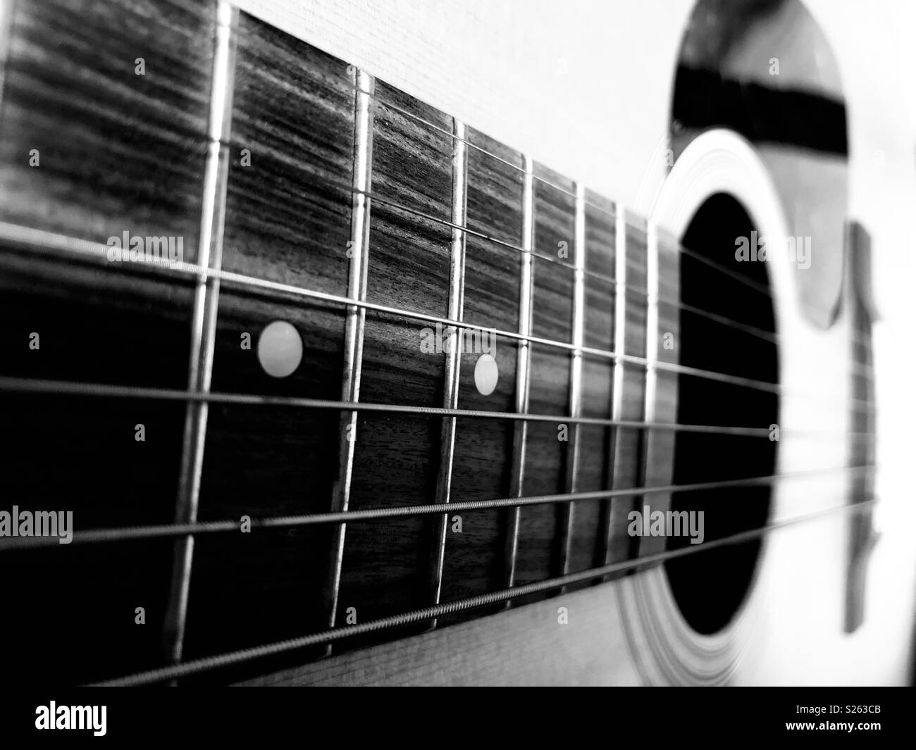 Nahaufnahme einer Gitarre in Schwarz und Weiß Stockfoto