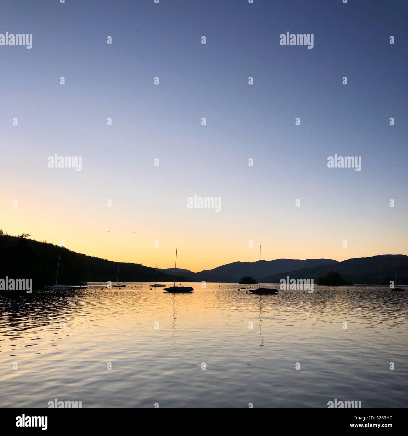 Sonnenuntergang am Lake Windermere mit kleinen Booten - Smartphone-aufgenommenes Stockfoto