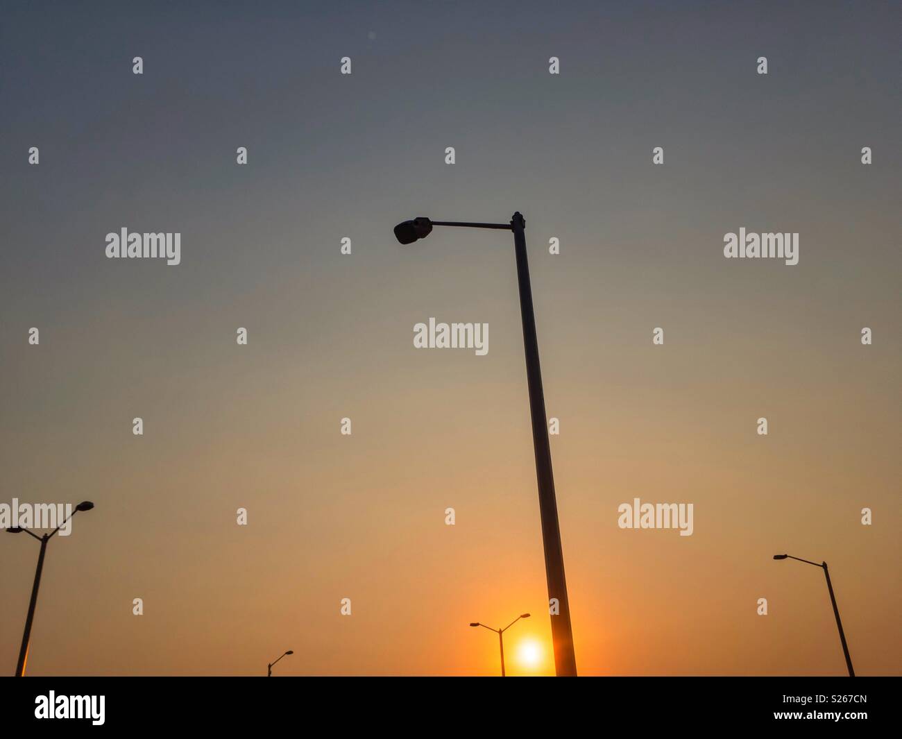 Sunrise und Strassenlaternen Silhouetten. Stockfoto