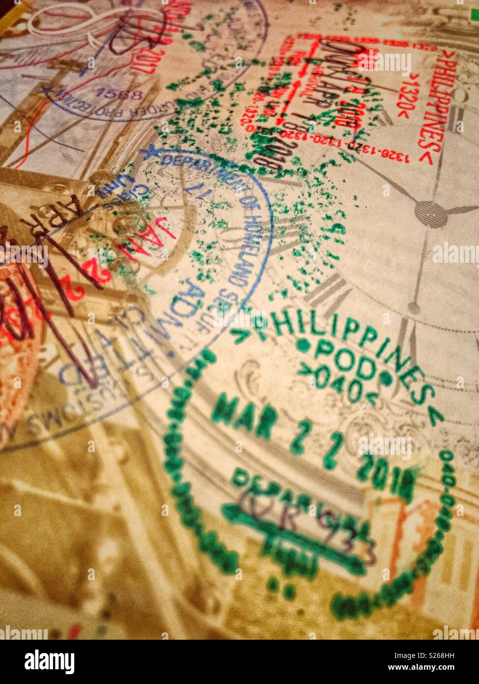 Makrofoto von Einwanderungsstempeln im britischen Pass mit Stempeln des Ministeriums für Heimatschutz, USA und der Philippinen - Smartphone-aufgenommenes Stockfoto