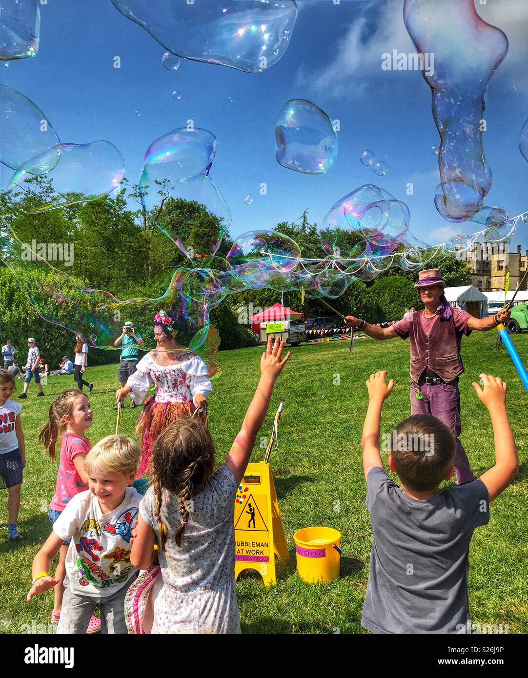 Bubbleman Erstellen von Seifenblasen, und Kinder, die versuchen, Sie zu Pop, Sherborne Castle Country Fair, Sherbourne, Dorset, England - Smartphone-aufgenommenes Stockfoto