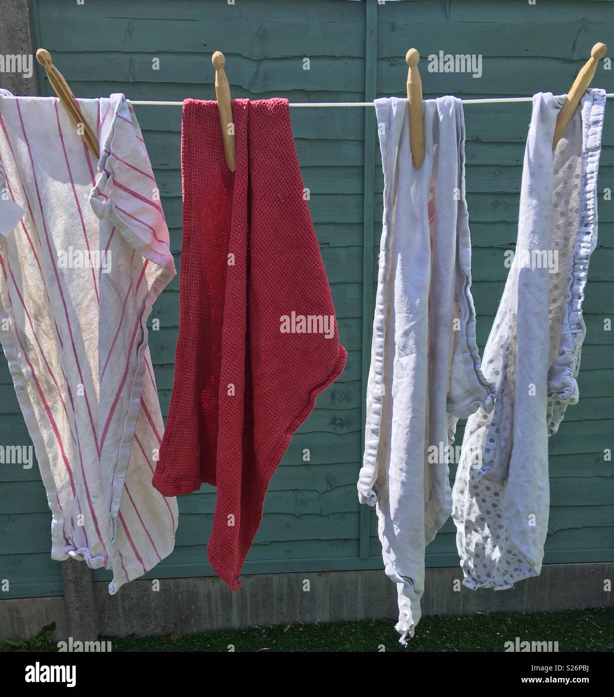Alte Handtücher auf einer Wäscheleine, die durch hölzerne Dolly statt Peg Stockfoto