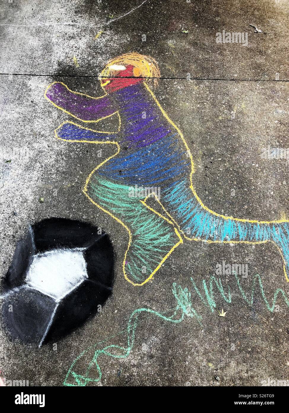 Zeichnung eines Kid spielen Fußball auf Asphalt - Smartphone-aufgenommenes Stockfoto