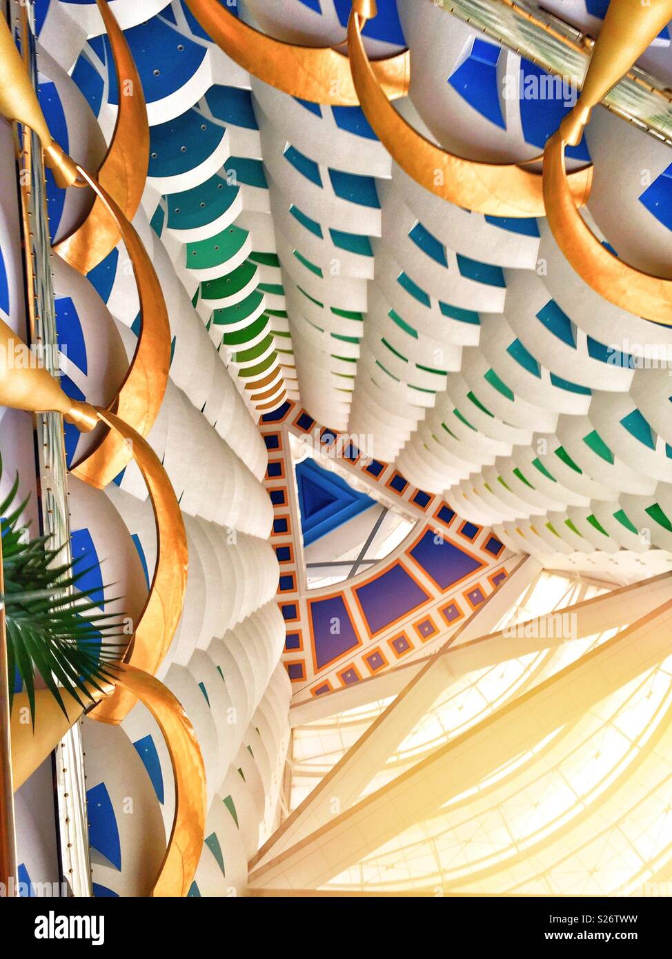 Blick aus dem Inneren des Burj Al Arab Dubai. Die farbenfrohen Balkone und Decken bilden eine abstrakte Kulisse mit dem Sonnenlicht, das in das Atrium strömt - Smartphone-aufgenommenes Stockfoto