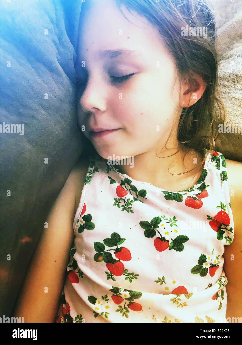 Schlafen 5 Jahre alten Mädchen mit einem rosa Erdbeere gemusterten Kleid Stockfoto