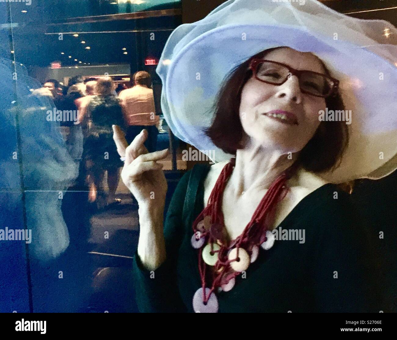 Frau mit Hut an der Unterbrechung. - Smartphone-aufgenommenes Stockfoto