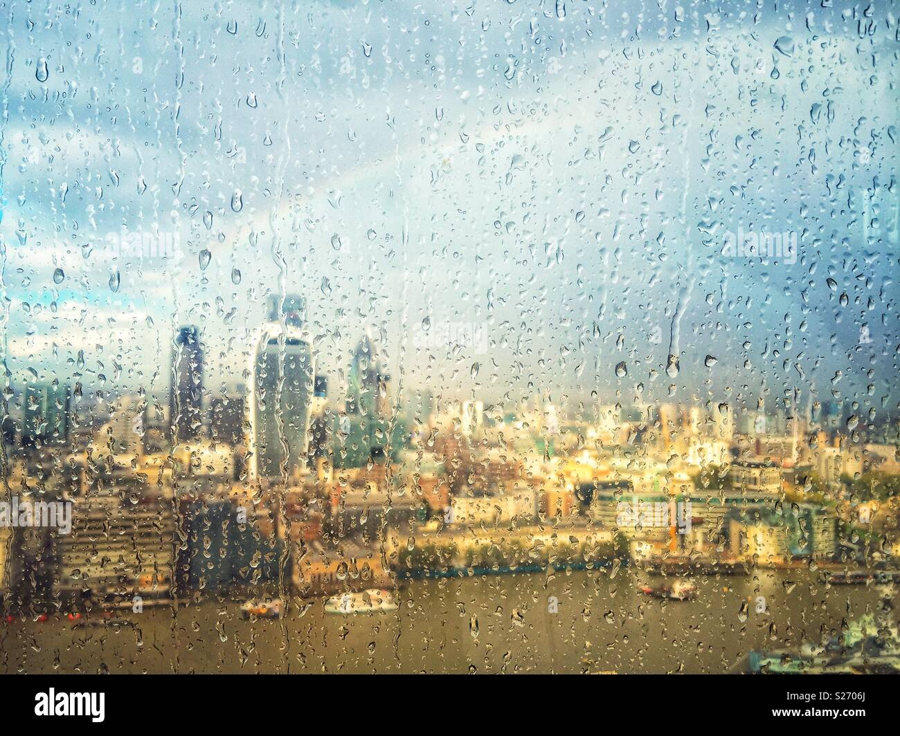Regen auf dem Fenster der Shard, London, UK, über die Themse in Richtung Fenchurch Street und über die Stadt. Ein Regenbogen der Himmel leuchtet wie die Sonne durch Brüche, beleuchtet die Stadt unten. Stockfoto