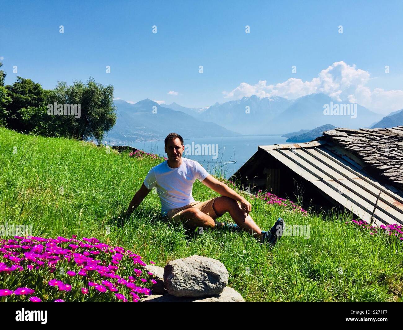 Mann sitzt auf einem Hügel über dem Comer see Stockfoto