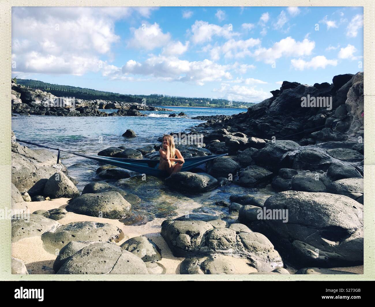 Meine süße Meerjungfrau Freund sitzen in einer Hängematte aus Felsen über Tide Pools aufgehängt. Honolua Bay, Maui. Stockfoto