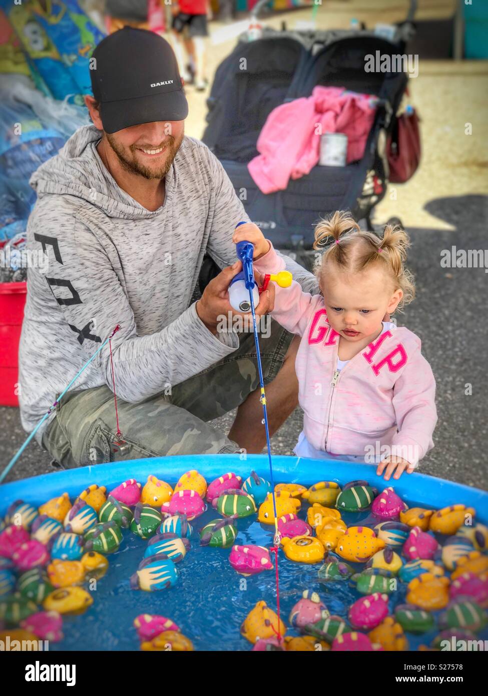 Vater und Tochter spielen der Angeln Spiel an einem Karneval Stockfoto