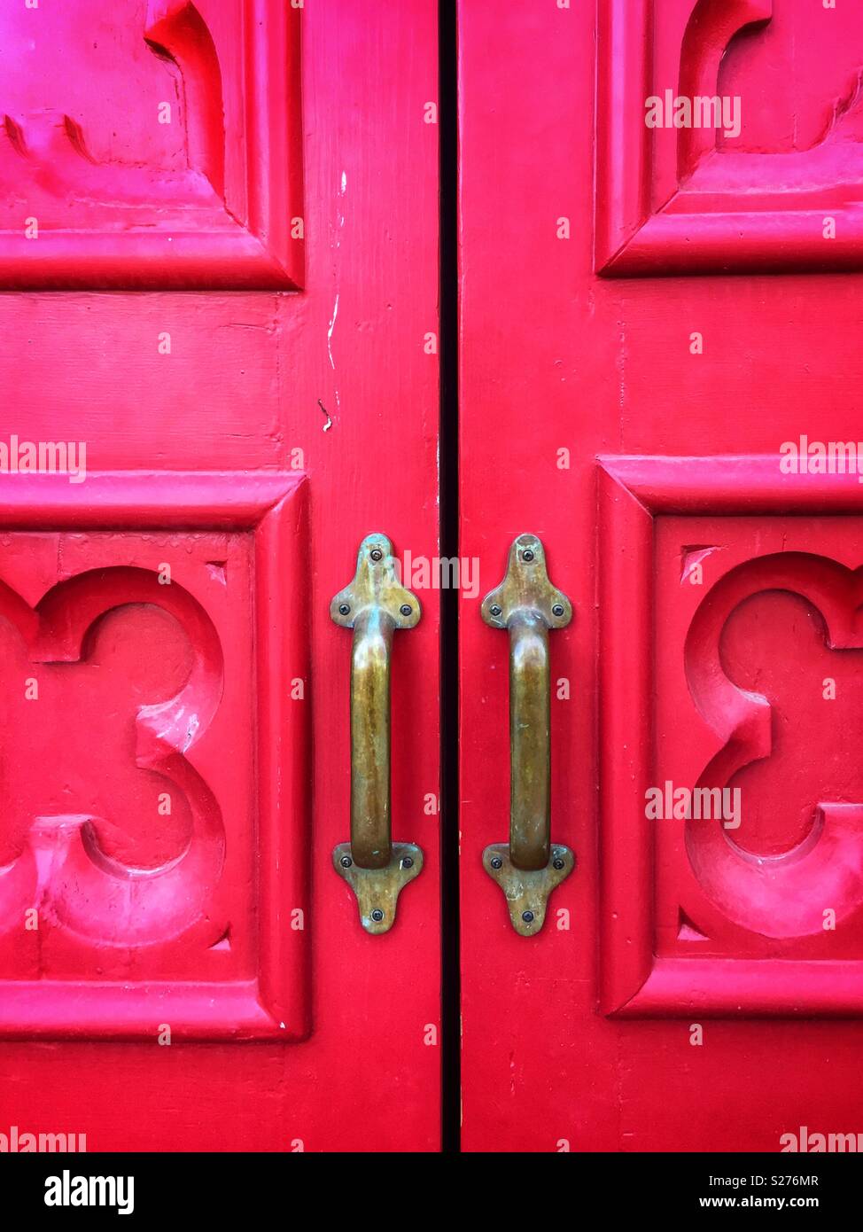Nahaufnahme von roten Türen mit Messing Griffe Stockfoto