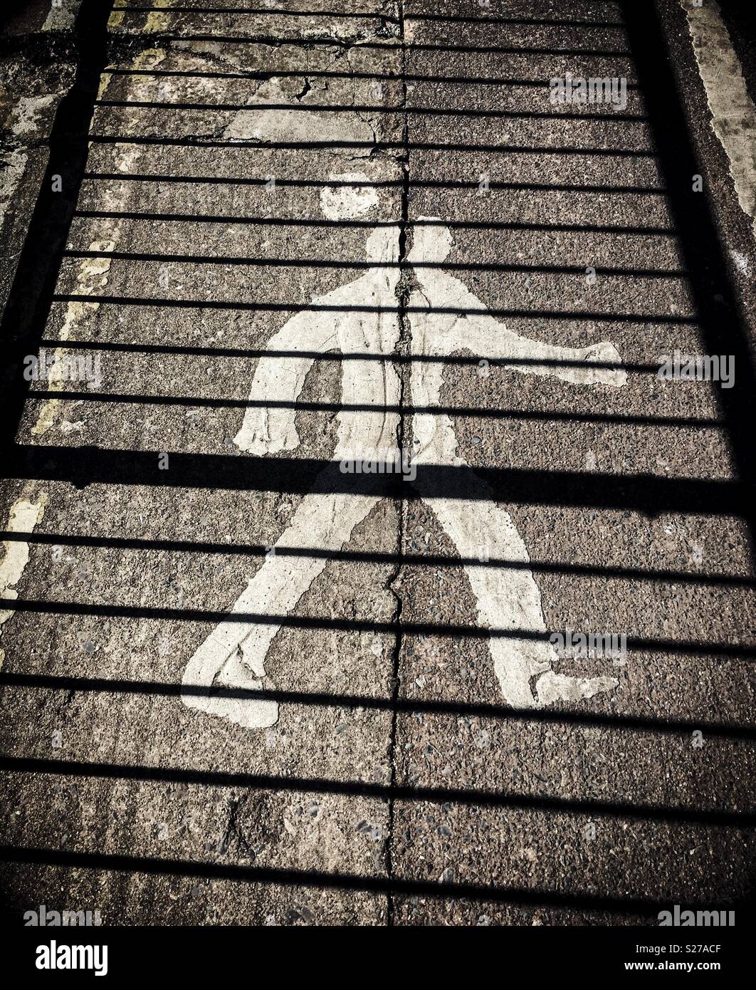 Fußgänger-Zeichen auf dem Boden mit Schatten der Geländer. Schwarz und Weiß Stockfoto