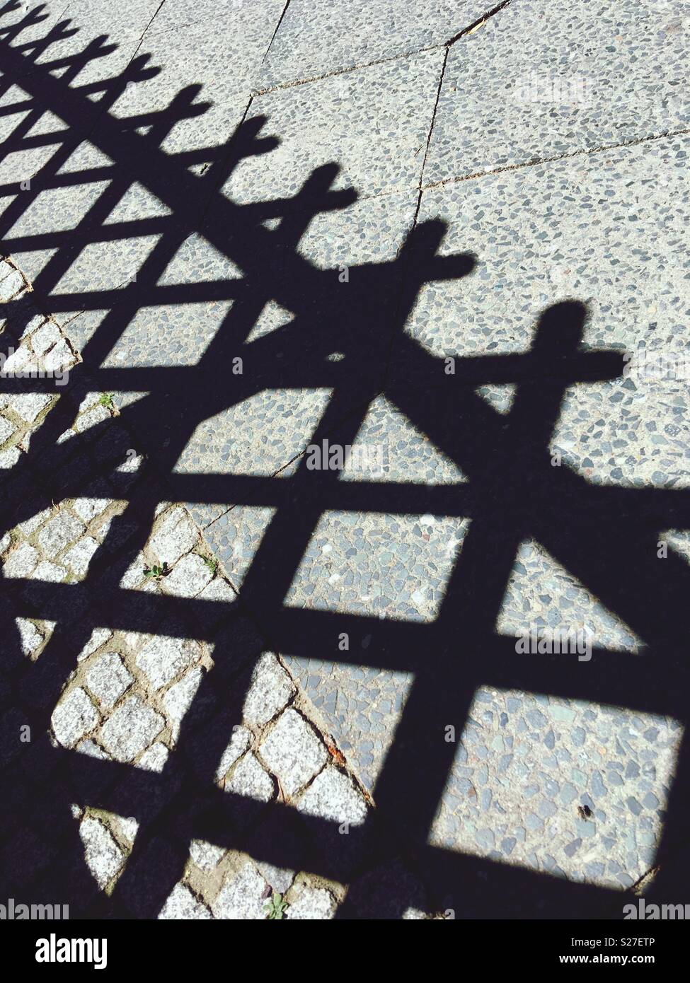 Schatten einer Holz- lattenzaun auf dem Bürgersteig Stockfoto