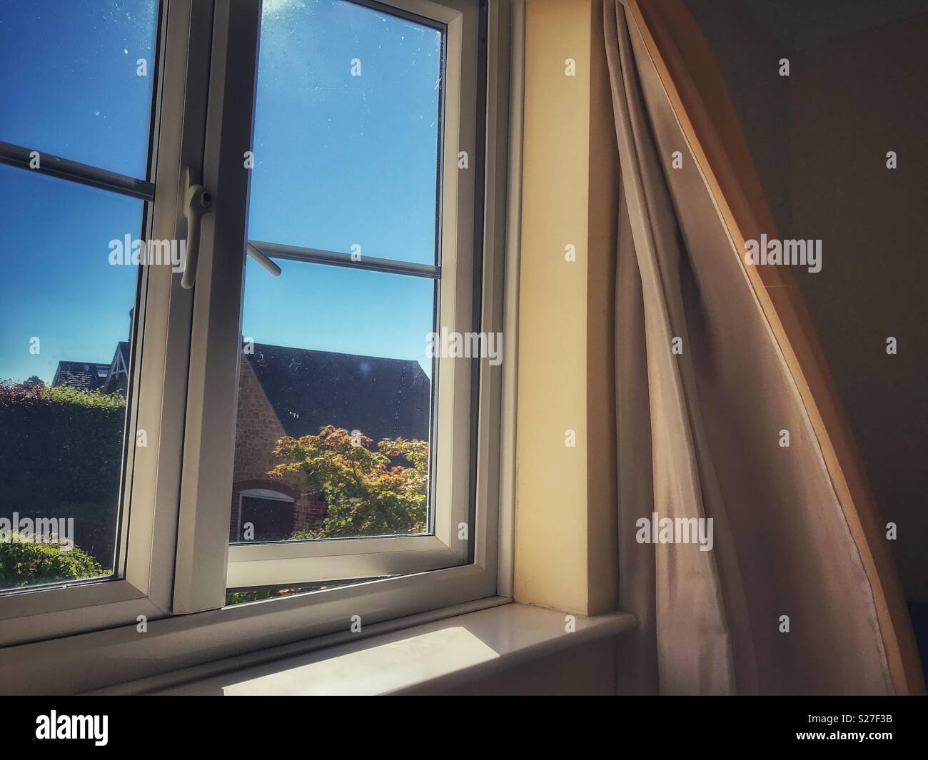 Blick durch Fenster mit Vorhang im Wind flattern - Smartphone-aufgenommenes Stockfoto