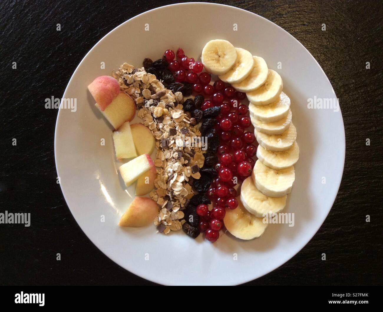 Erhöhten Blick auf Müsli und frischem Obst für das Müsli Frühstück auf weiße Platte Stockfoto