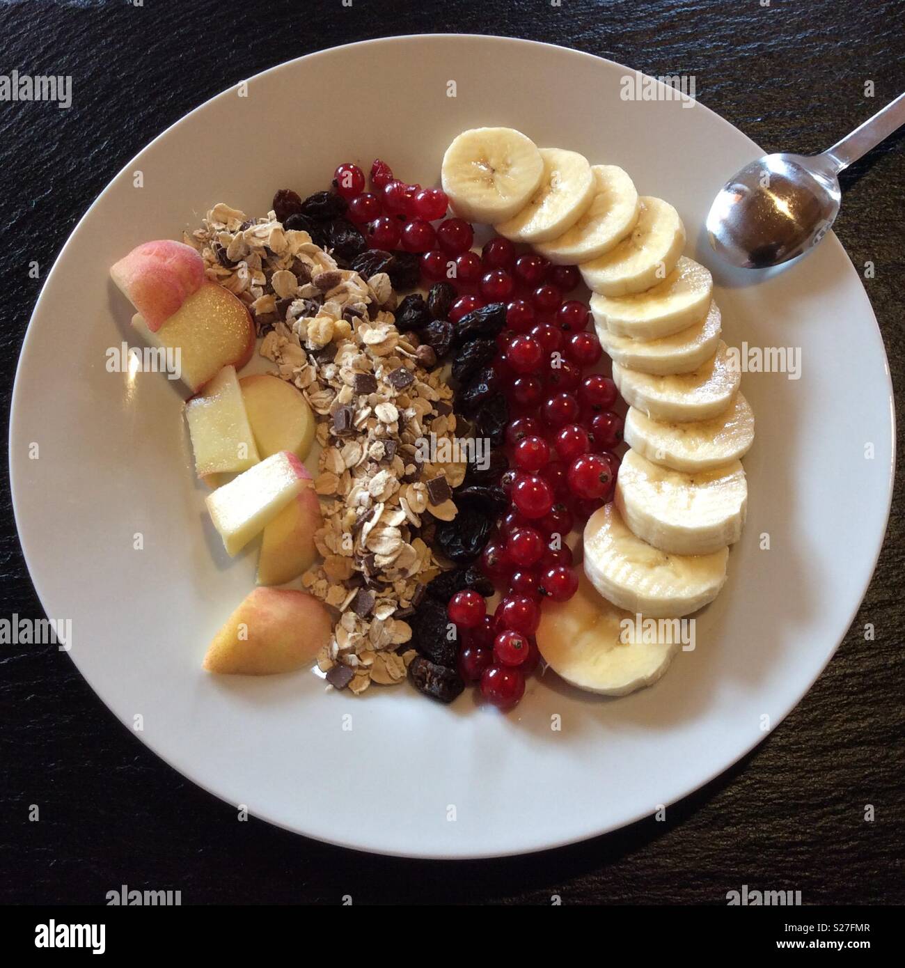 Erhöhten Blick auf Müsli Frühstück auf weißen Teller und Löffel Stockfoto