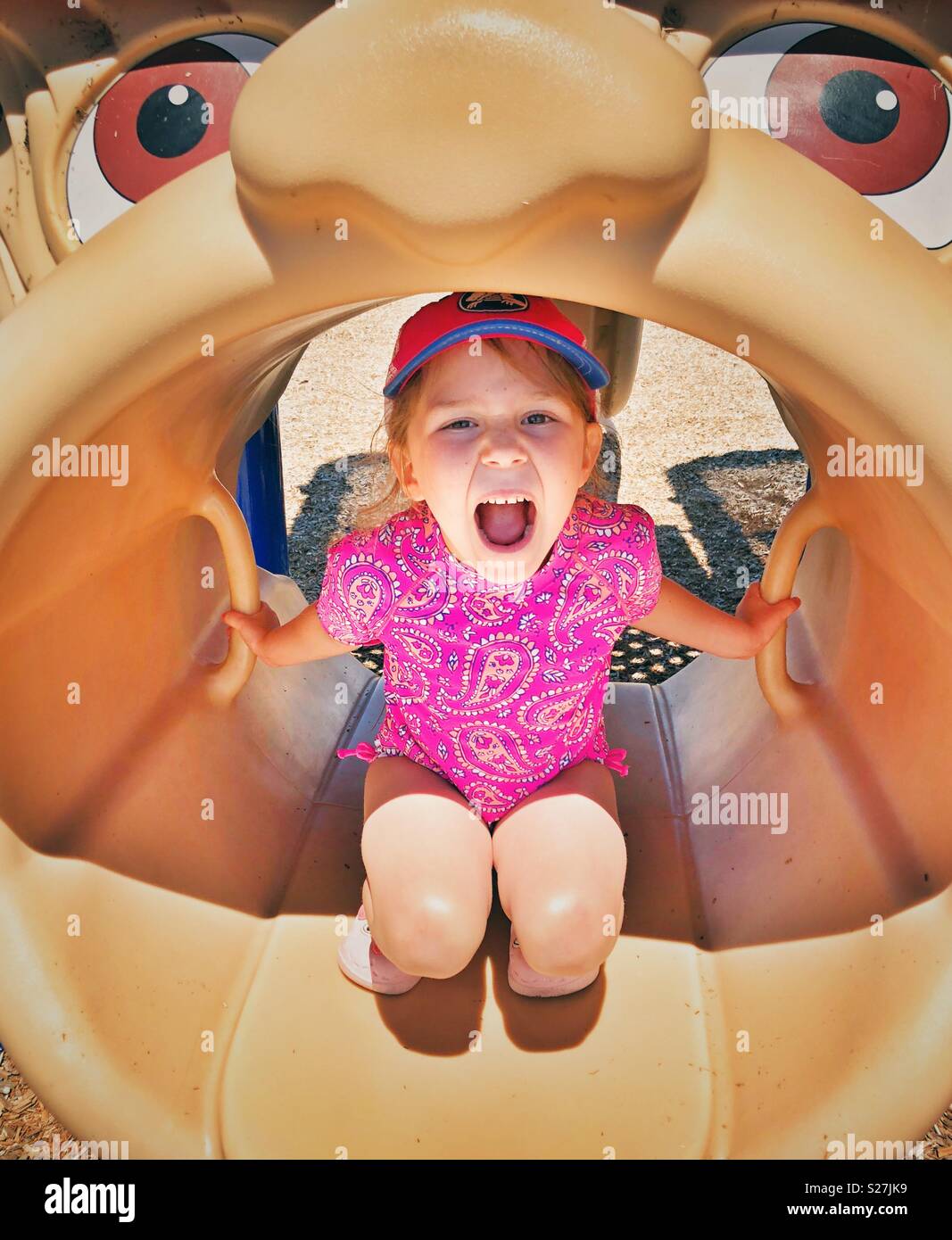 Fünf Jahre altes Mädchen Spaß und schreiend in einem offenem Mund spielen Struktur auf einem öffentlichen Spielplatz Stockfoto