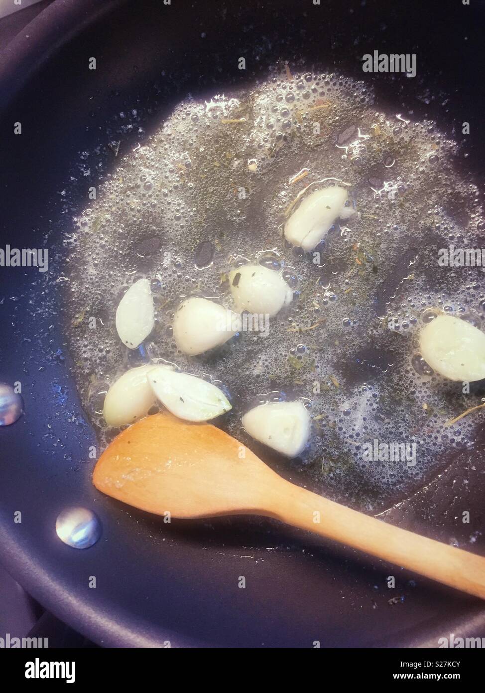 Zehen Knoblauch gebraten in Olivenöl und Butter in einen Topf geben, Kochplatten, USA Stockfoto