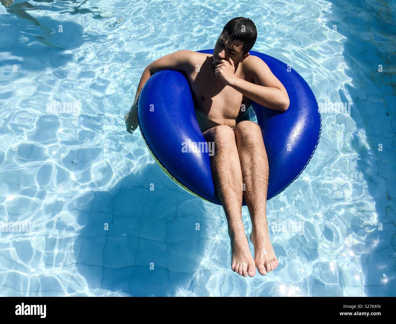Jugendlicher auf einen Schwimmer in einem Pool Stockfoto
