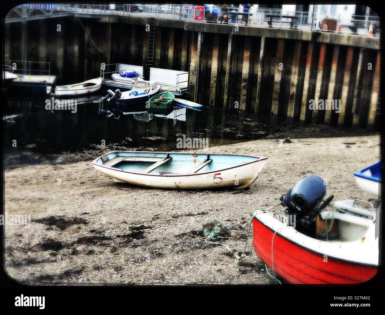 Auf Sand mit kleinen Booten von Pier in Ullapool im Juli Beiboot - Smartphone-aufgenommenes Stockfoto
