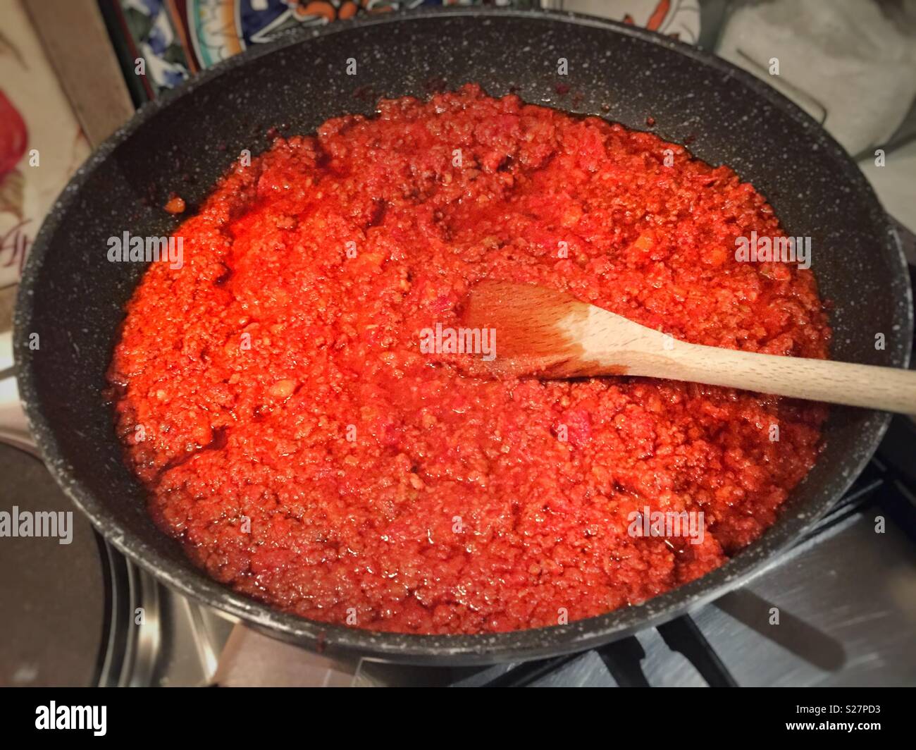 Vorbereitung der Italienischen "ragu'" Sauce mit einem Holzlöffel Stockfoto