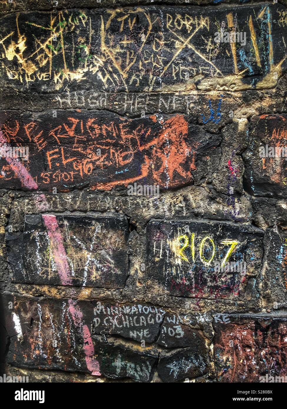 Eine schwarze Wand mit Kreide Worte gekritzelt alle über sie Stockfoto