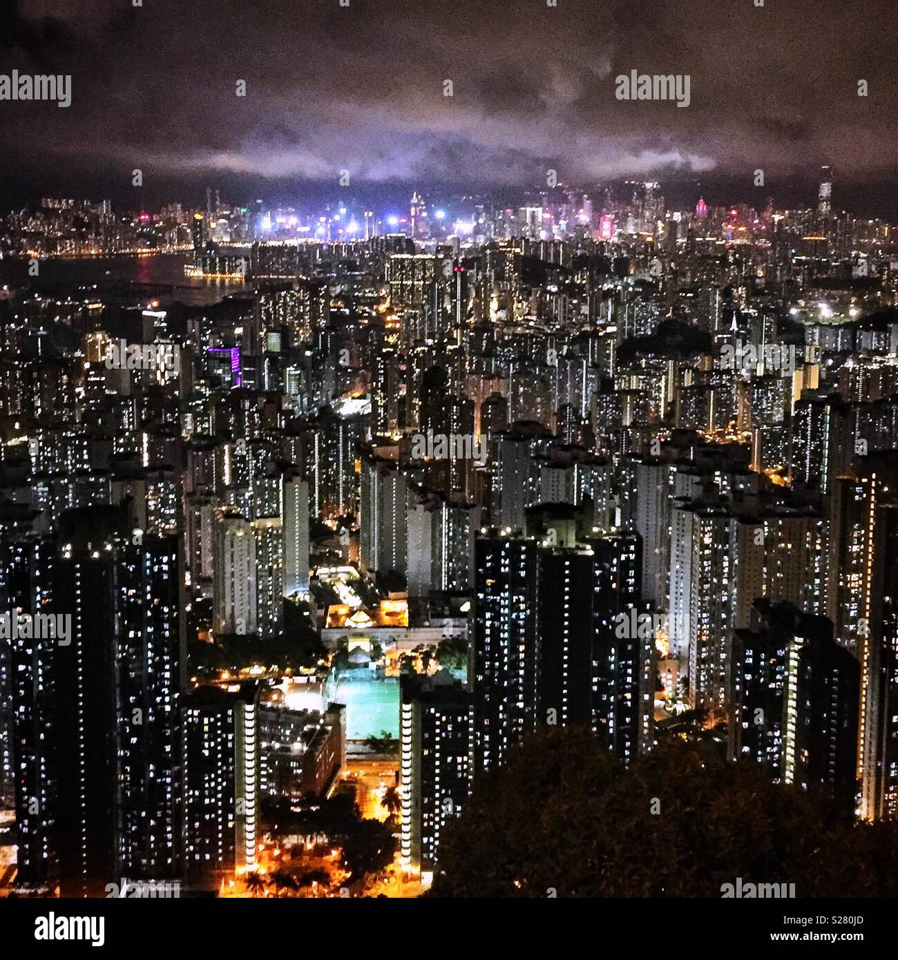 Die hellen Lichter von Hong Kong Island und Tsim Sha Tsui über die hohe Dichte urbane Landschaft der Halbinsel Kowloon aus dem alten Sha Tin Pass Road, Hong Kong (neutralen Ton gesehen). Stockfoto