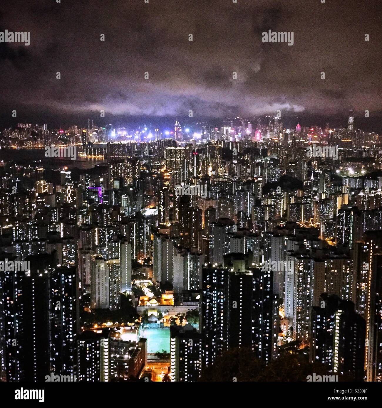Die hellen Lichter von Hong Kong Island und Tsim Sha Tsui über die hohe Dichte urbane Landschaft der Halbinsel Kowloon aus dem alten Sha Tin Pass Road, Hong Kong (neutralen Ton gesehen). Stockfoto
