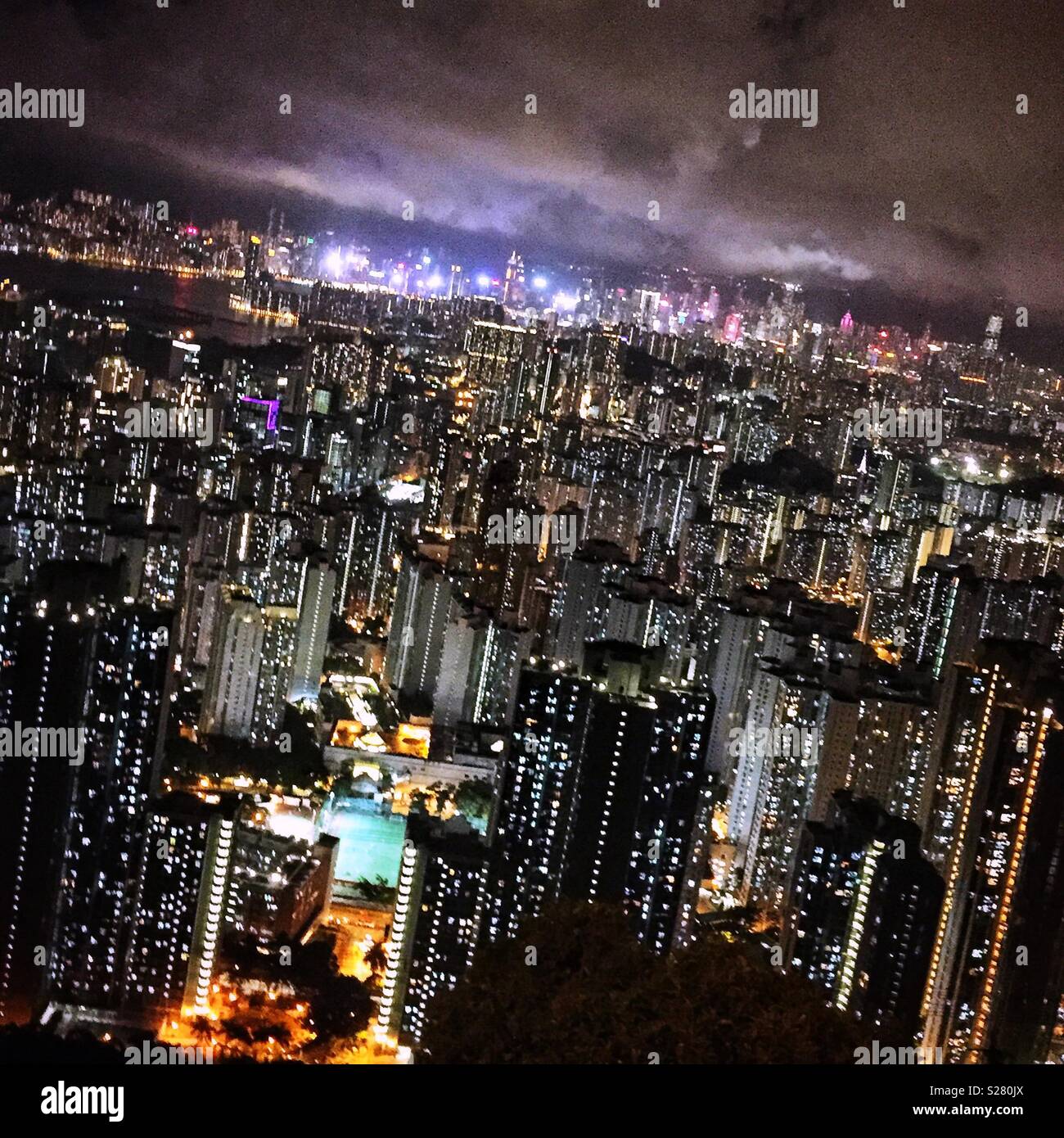 Die hellen Lichter von Hong Kong Island und Tsim Sha Tsui über die hohe Dichte urbane Landschaft der Halbinsel Kowloon aus dem alten Sha Tin Pass Road, Hong Kong (neutralen Ton gesehen). Stockfoto