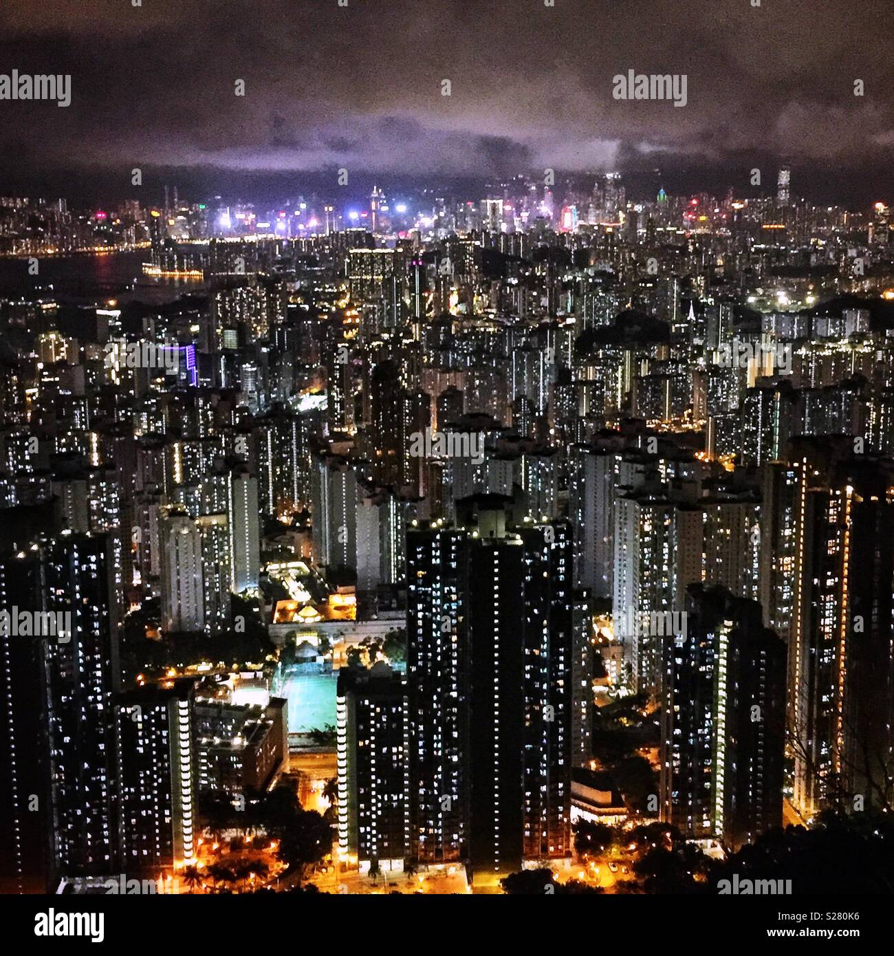 Die hellen Lichter von Hong Kong Island und Tsim Sha Tsui über die hohe Dichte urbane Landschaft der Halbinsel Kowloon aus dem alten Sha Tin Pass Road, Hong Kong (neutralen Ton gesehen). Stockfoto