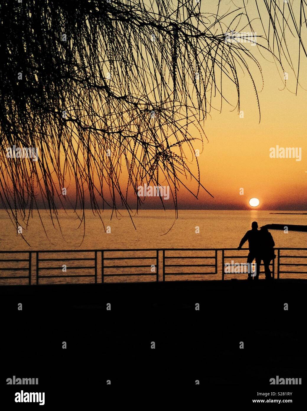 Paar in der Liebe genießen den Sonnenuntergang am Strand - Smartphone-aufgenommenes Stockfoto