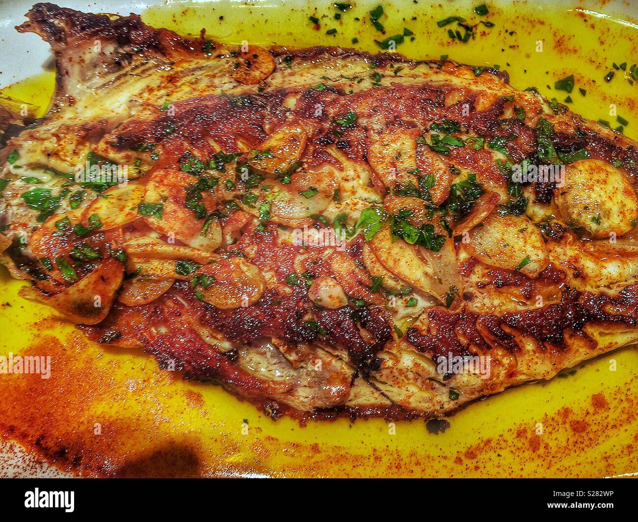 Ganze Abgeflacht gebratene Makrele im spanischen Stil mit Knoblauch und Gewürzen Stockfoto