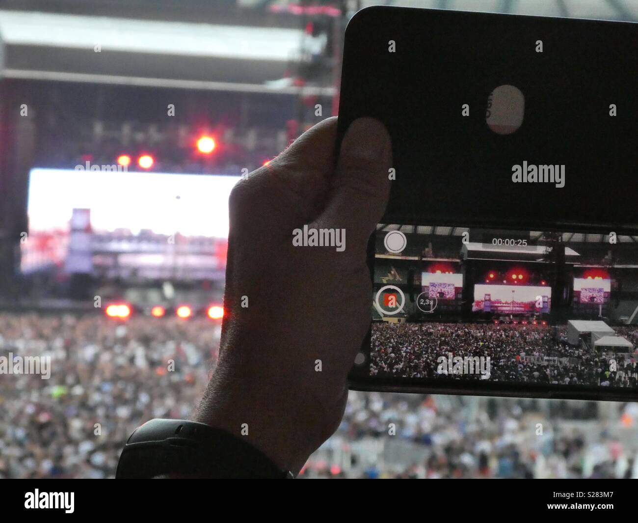 Die Aufnahme ein Video von einem Konzert auf einem Mobiltelefon Stockfoto