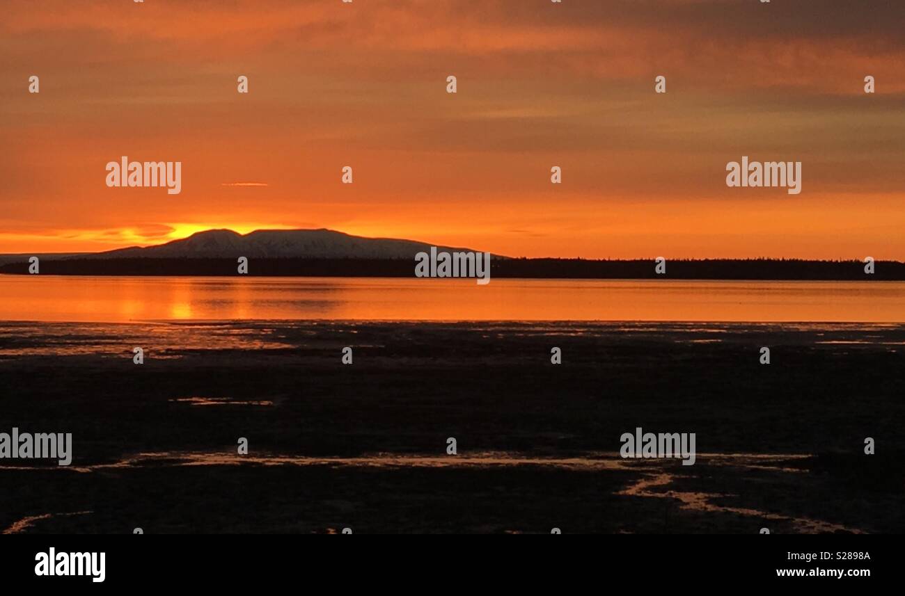 Sonnenuntergang hinter dem "Sleeping Lady" (Mount Susitna) in Anchorage, Alaska. - Smartphone-aufgenommenes Stockfoto