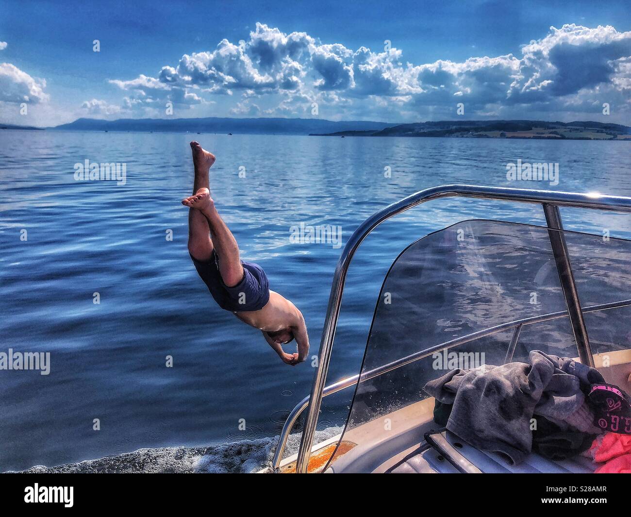 Mann springen vom Boot aus Stockfoto