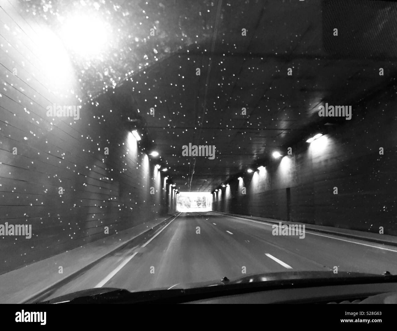 Fahren durch einen Tunnel mit Regentropfen auf der Windschutzscheibe Stockfoto