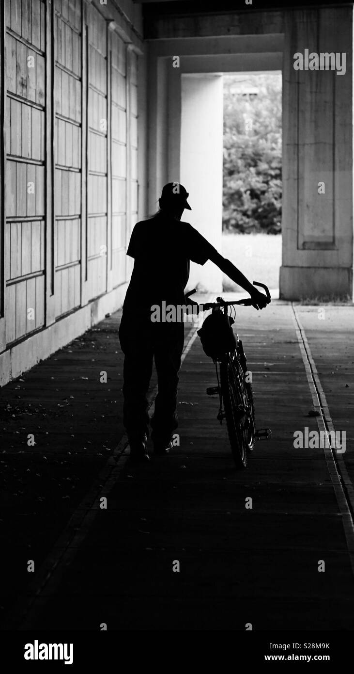 Einsamer Mann alleine zu Fuß Fahrrad Stockfoto
