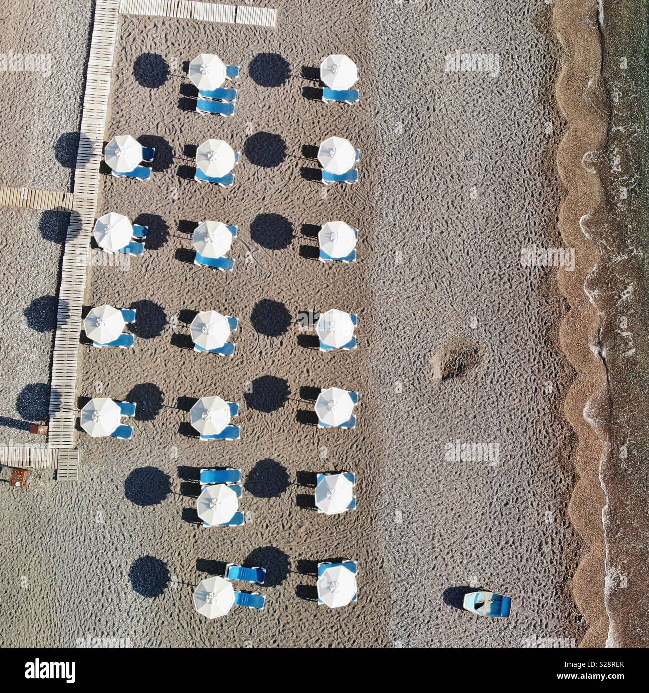 Sonnenschirme und Boot auf den Strand Stockfoto