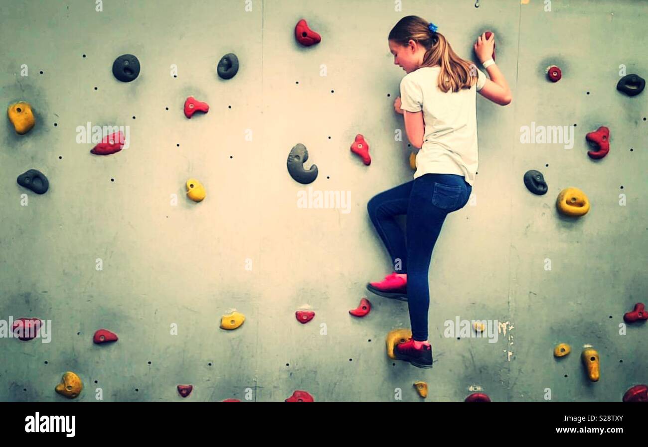Junges Mädchen an einer Kletterwand Stockfoto