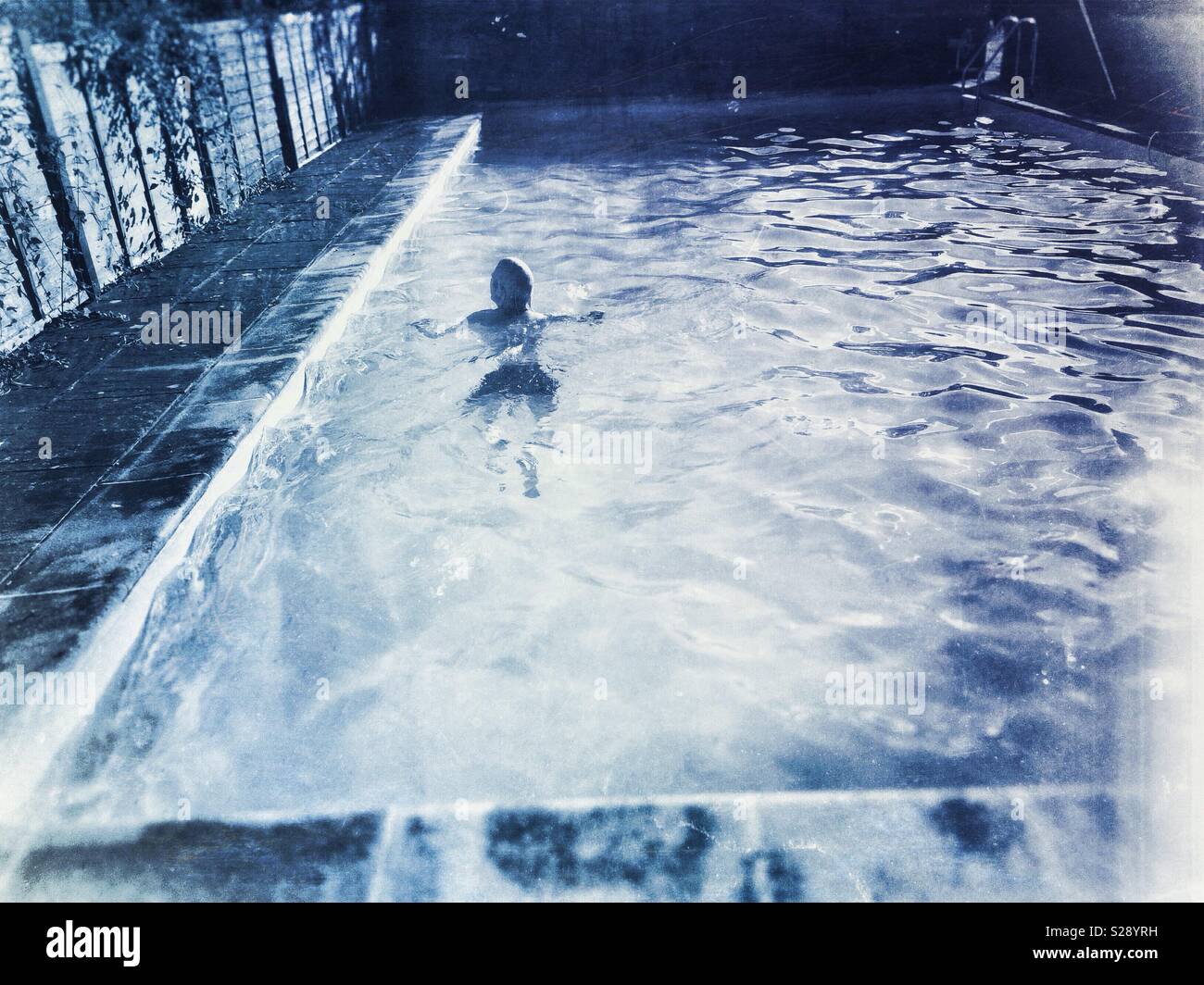 Mann Schwimmen allein in einer kleinen, privaten Pool - Smartphone-aufgenommenes Stockfoto