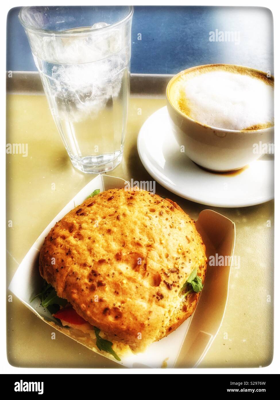 Waitrose Cafe glutenfrei Ei und Tomate Roll-, Cappuccino- und stilles Wasser - Smartphone-aufgenommenes Stockfoto