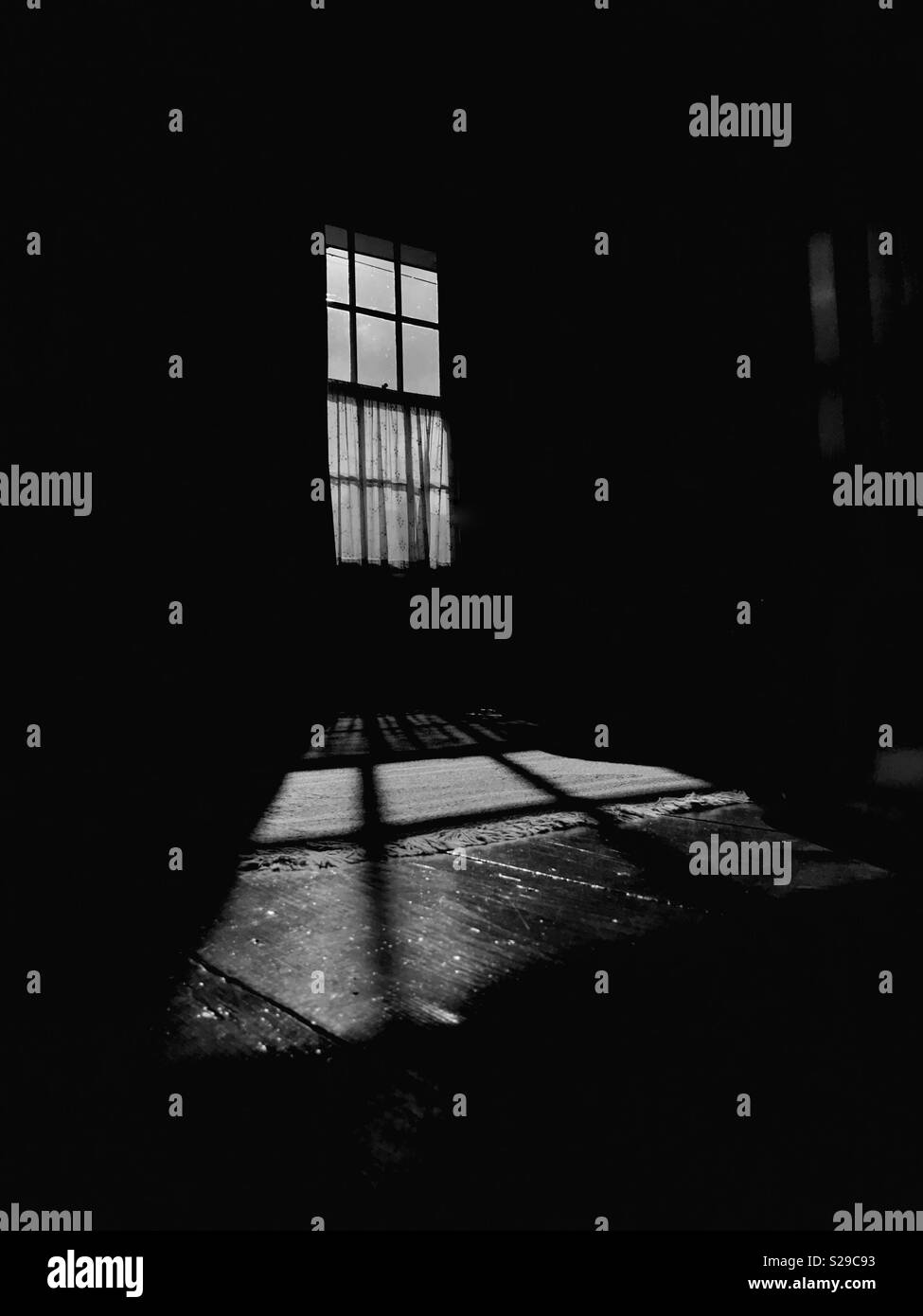 Ein schwarz-weiß Bild von einer traditionellen Schiebefenster Casting eine harte Schatten auf dem Boden. Stockfoto