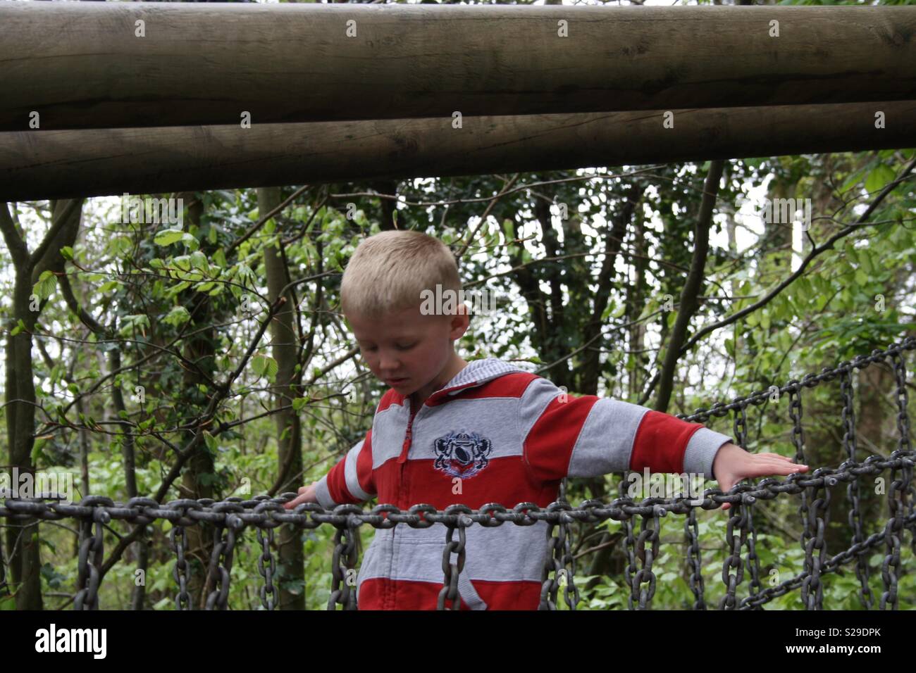 Junge Konzentration gehen über eine Metallbrücke Stockfoto