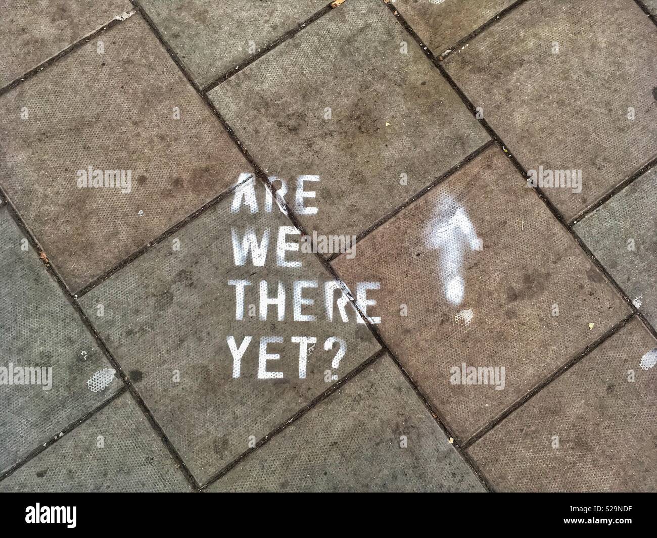 Der Slogan "Sind wir schon da?" Auf einer schmutzigen pflaster gemalt Stockfoto